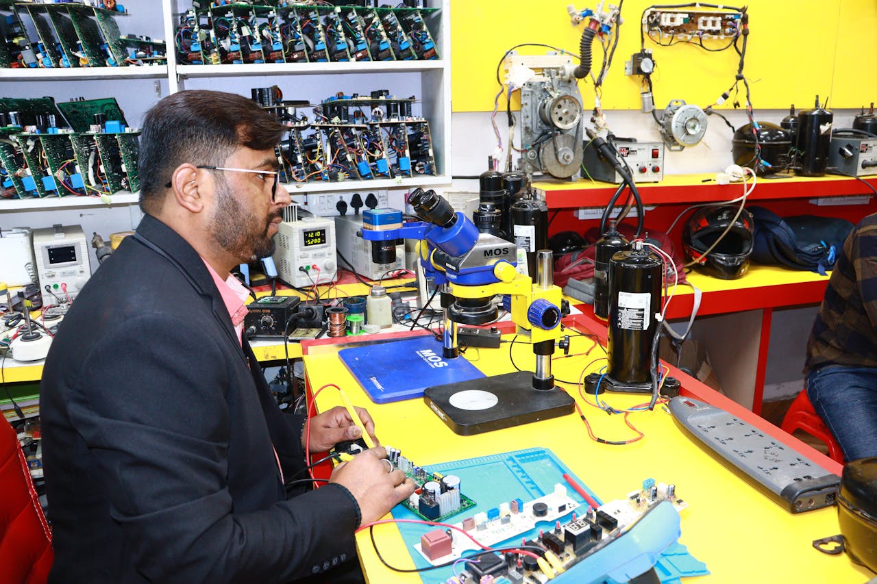 A man in Delhi working in an electronics lab with tools and components.